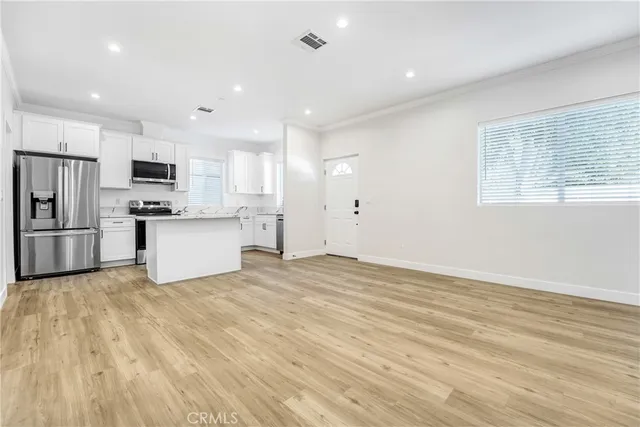 a view of kitchen with wooden floor and electronic appliances
