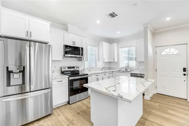 a kitchen with white cabinets and stainless steel appliances