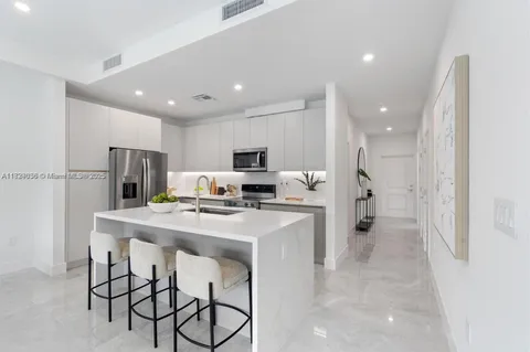 a kitchen with stainless steel appliances a refrigerator and a stove top oven