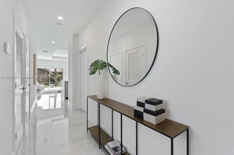 a picture of a room with wooden floor and mirror