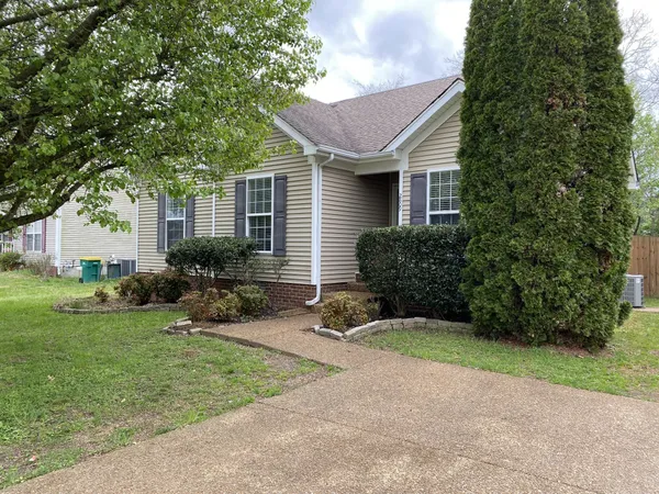 a front view of a house with yard and green space