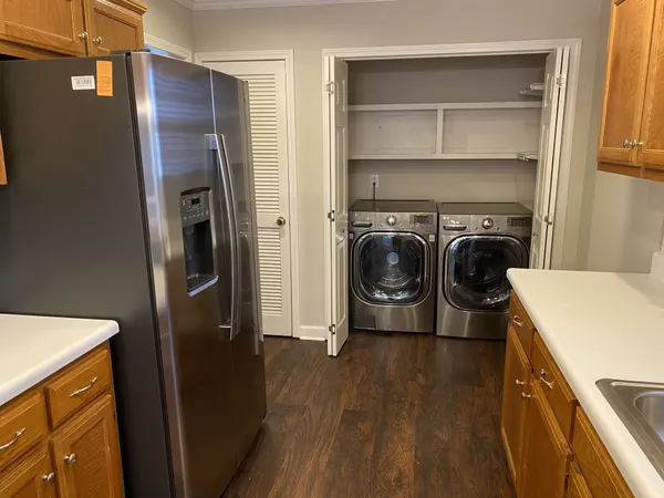 a utility room with wooden floor washer and dryer