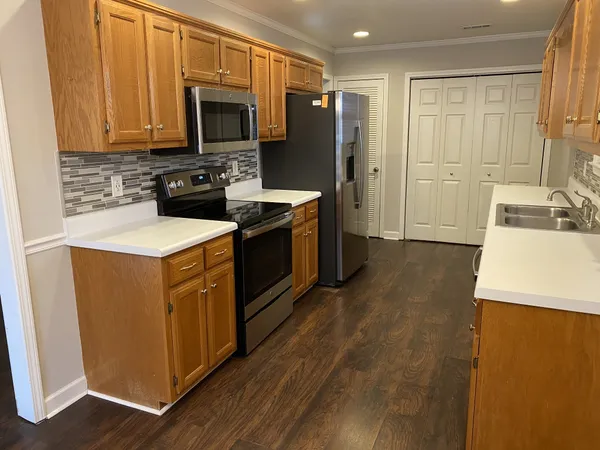 a kitchen with stainless steel appliances granite countertop a stove a sink and a refrigerator