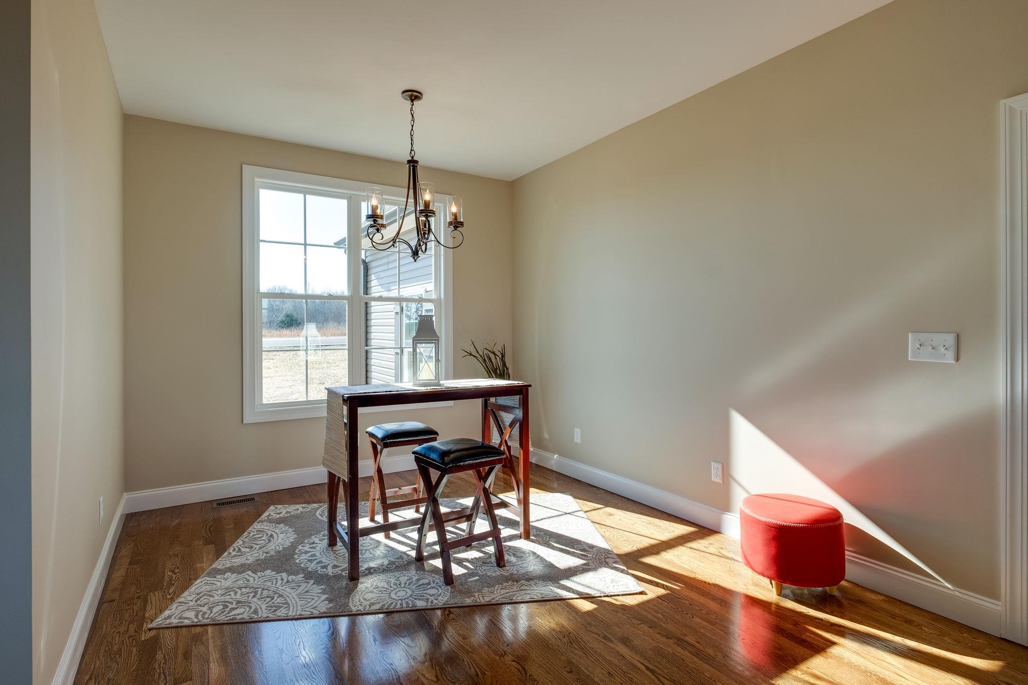 1809 Abiff Road Burns, TN 37029 - Photo 10 of 28 a dining room with wooden floor a chandelier a wooden table and chairs
