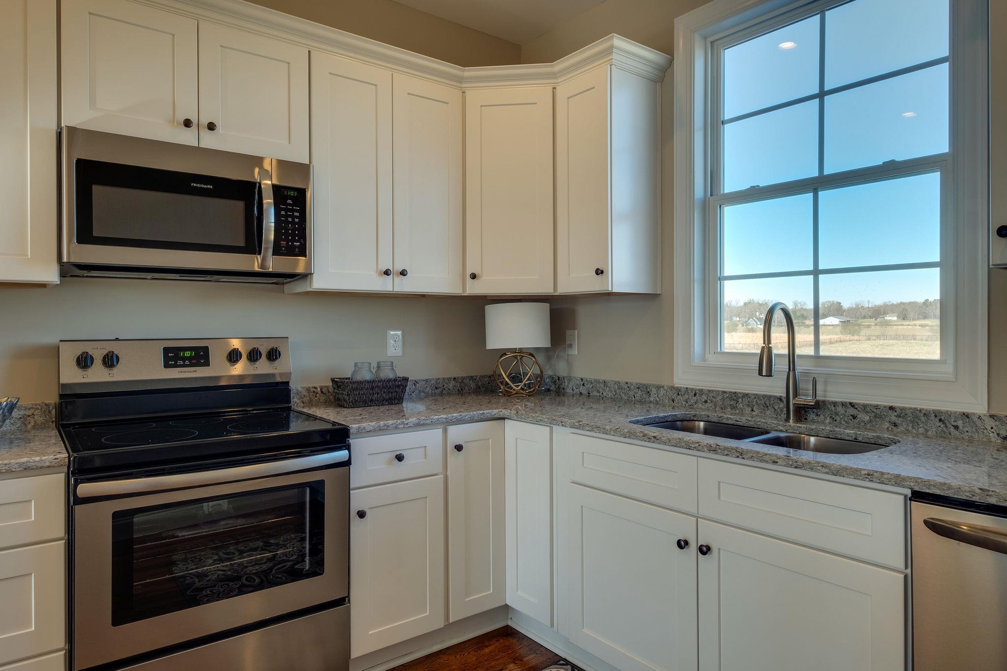 1809 Abiff Road Burns, TN 37029 - Photo 11 of 28 a kitchen with granite countertop white cabinets stainless steel appliances and a sink