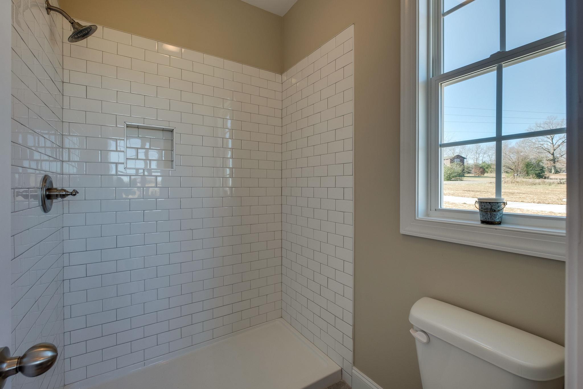 1809 Abiff Road Burns, TN 37029 - Photo 20 of 28 a bathroom with a toilet a sink a shower and mirror