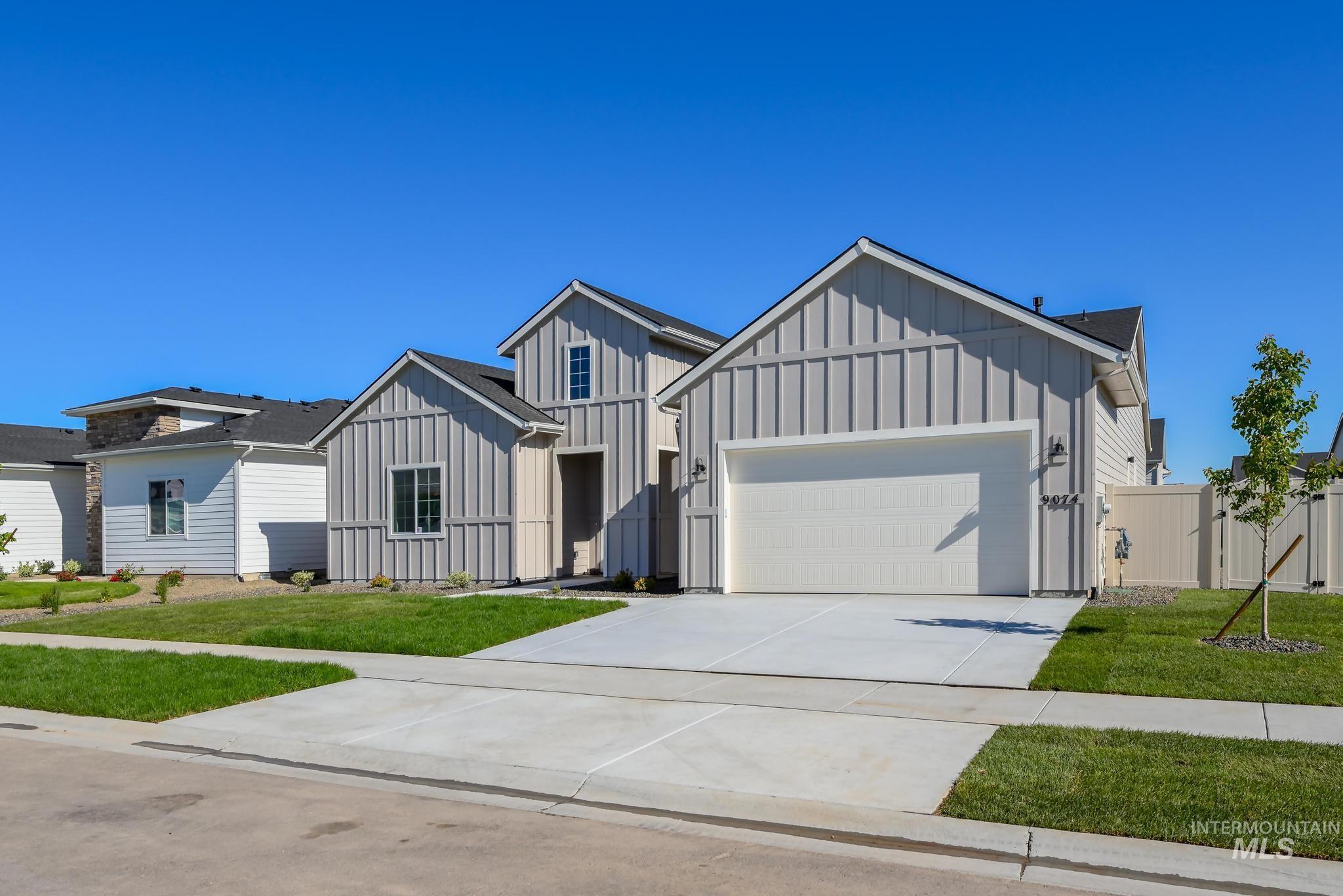 9074 West Moonglade Street Star, ID 83669 - Photo 3 of 40 Modern farmhouse-style exterior featuring board and batten siding, a two-car garage, concrete driveway, and a manicured lawn