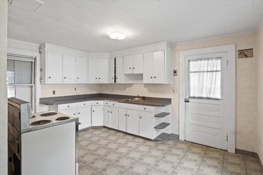 50 Clark Street Dedham, MA 02026 - Photo 3 of 38 a kitchen with granite countertop white cabinets and white appliances
