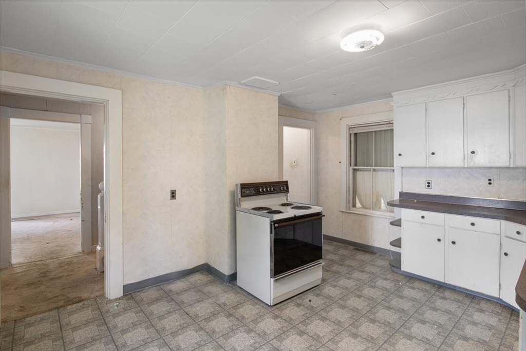 50 Clark Street Dedham, MA 02026 - Photo 4 of 38 a kitchen with granite countertop a stove top oven and cabinets