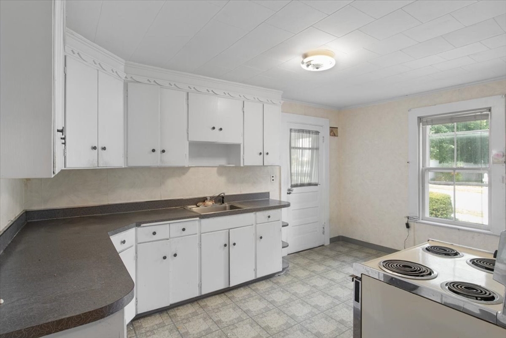 50 Clark Street Dedham, MA 02026 - Photo 5 of 38 a kitchen with granite countertop a sink stove and cabinets