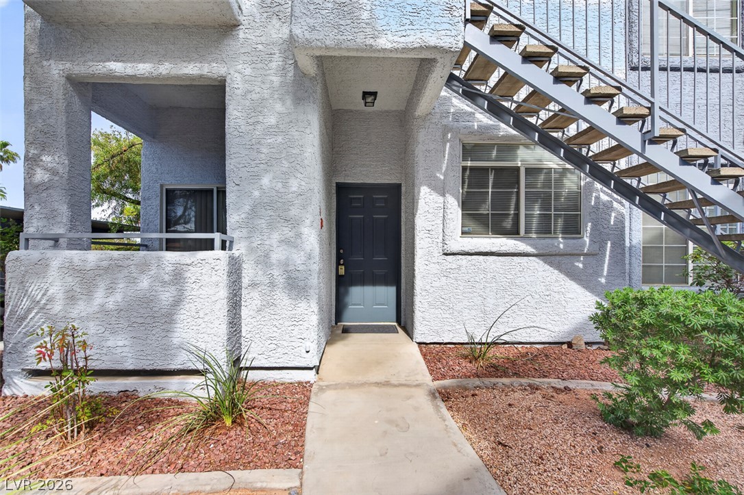 2201 Ramsgate Drive, Unit 1011 Henderson, NV 89074 - Photo 3 of 40 A welcoming entry invites residents, featuring a light-colored stucco exterior and a functional outdoor staircase.