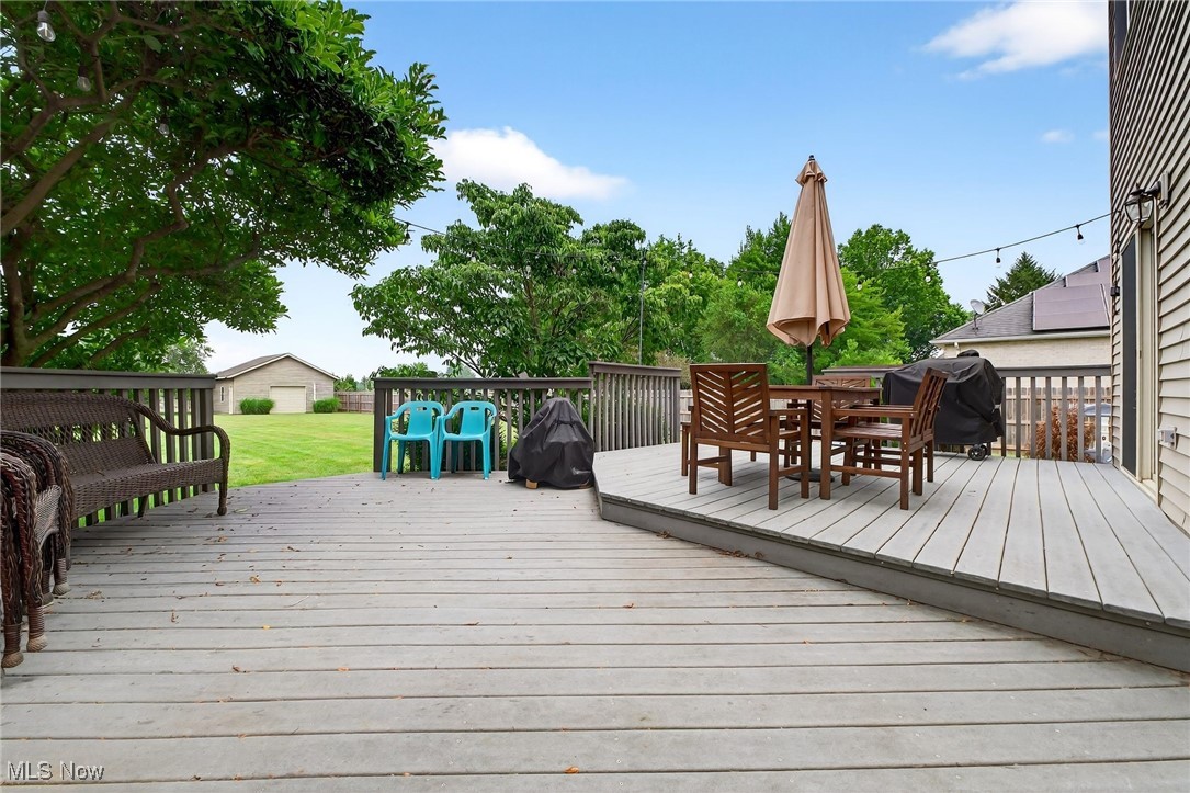 35748 Mills Road Avon, OH 44011 - Photo 33 of 44 Wooden terrace featuring outdoor dining space, grilling area, and a yard