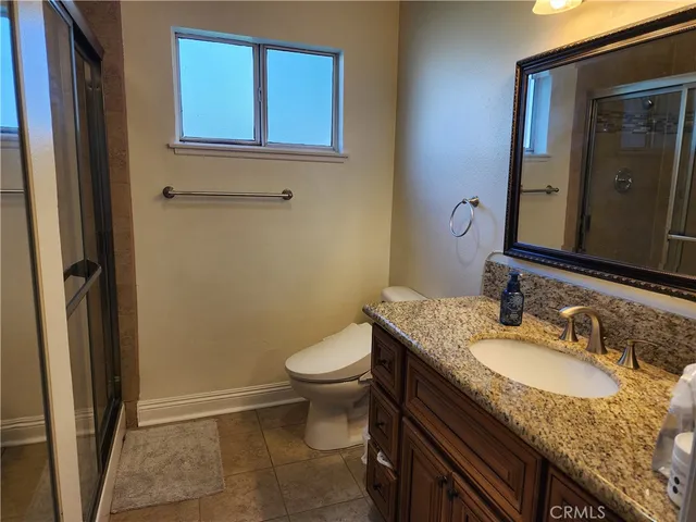 a bathroom with a granite countertop sink toilet and shower