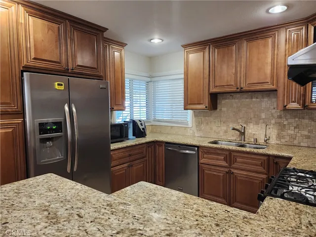 a kitchen with stainless steel appliances granite countertop a refrigerator sink and cabinets