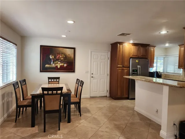 a dining room with furniture and kitchen view