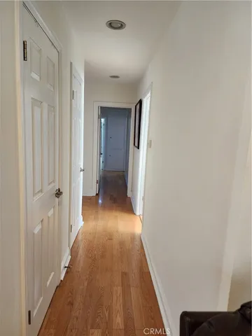 a view of a hallway with wooden floor