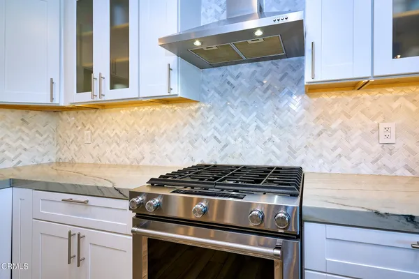 a kitchen with stainless steel appliances granite countertop a stove and cabinets
