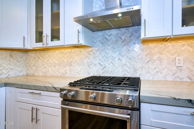a kitchen with stainless steel appliances granite countertop a stove and cabinets