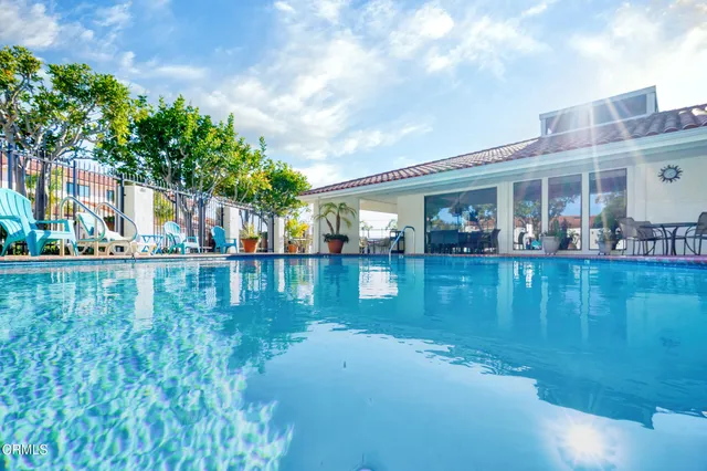 a living room with furniture a flat screen tv and floor to ceiling window