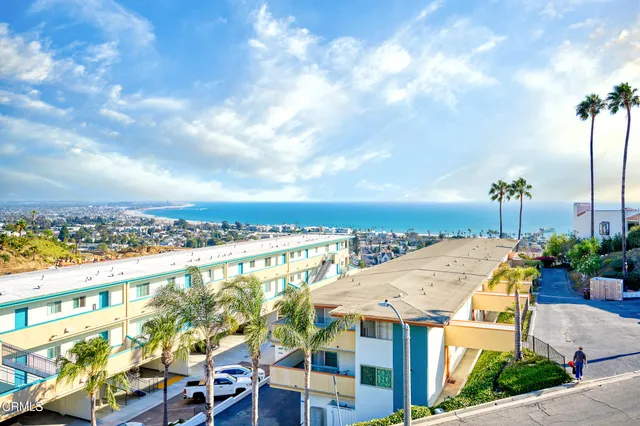 a view of a balcony with furniture and floor to ceiling window