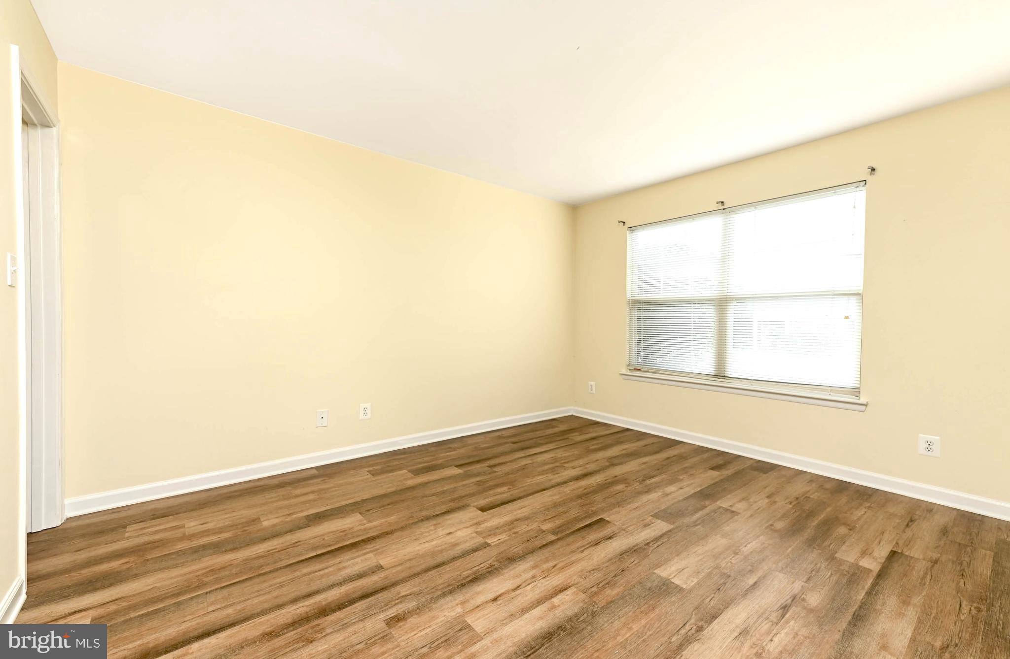 1706 Ascot Way, Unit B Reston, VA 20190 - Photo 11 of 14 an empty room with wooden floor and windows