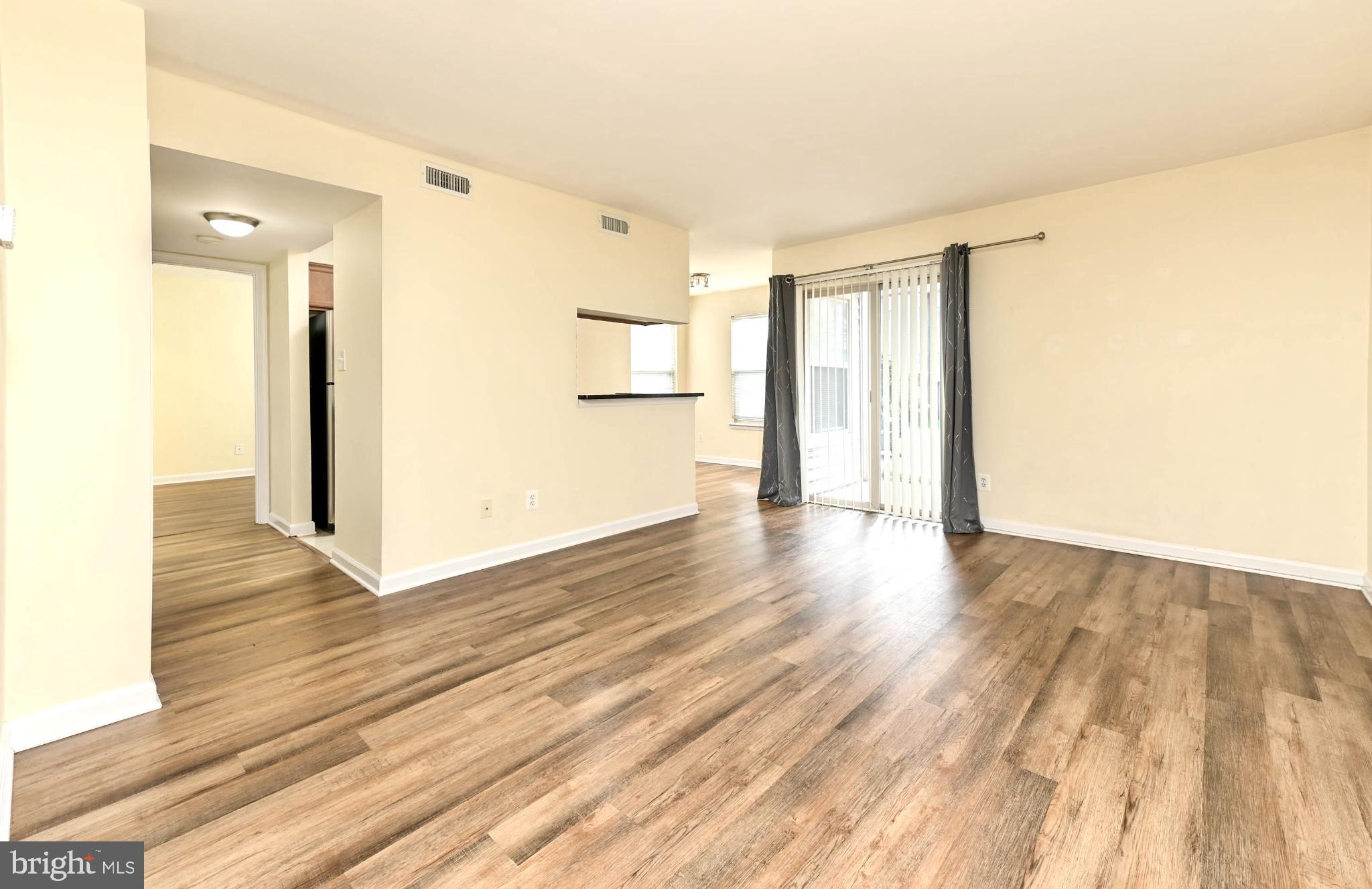 1706 Ascot Way, Unit B Reston, VA 20190 - Photo 3 of 14 a view of an empty room with wooden floor and a window