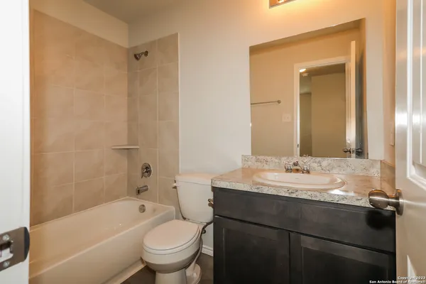 a bathroom with a granite countertop sink a toilet and a mirror