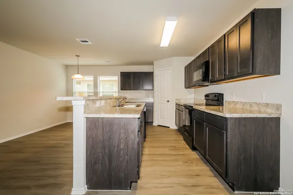 a kitchen with kitchen island granite countertop wooden cabinets a sink and dishwasher