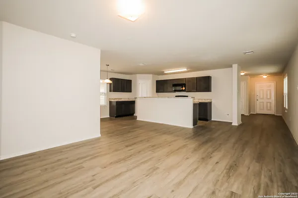a view of empty room with wooden floor and large window
