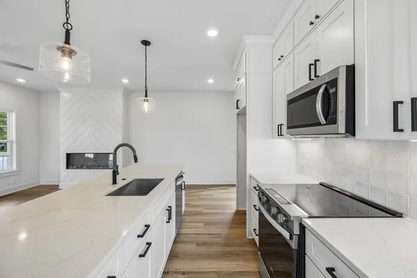 a kitchen with stainless steel appliances granite countertop a sink stove and refrigerator