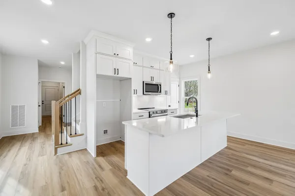 a kitchen with stainless steel appliances granite countertop a sink a stove and a refrigerator