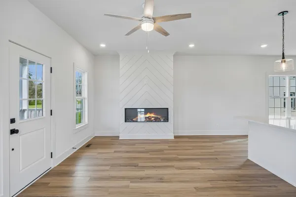 a view of a hallway with wooden floor and stairs