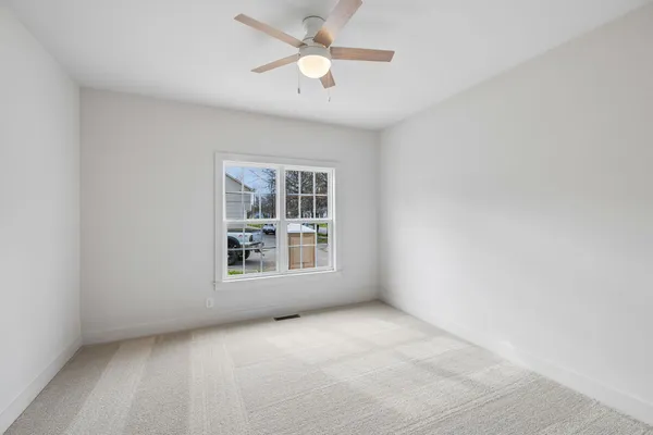 an empty room with a window and a fan