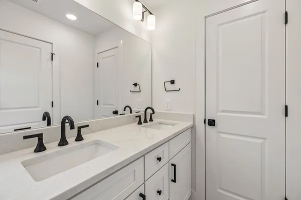 a bathroom with a double vanity sink mirror and toilet