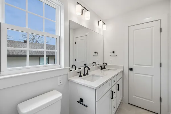 a bathroom with double vanity sinks and a mirror