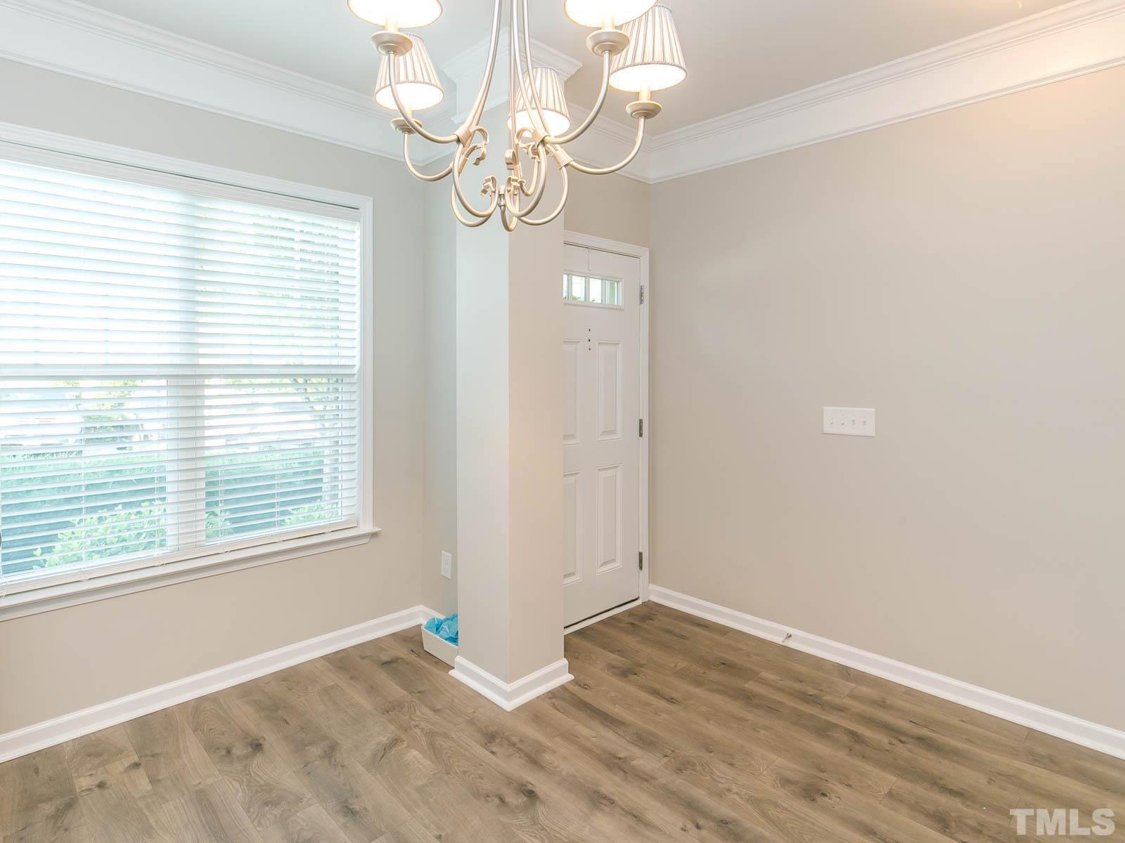 131 Deacon Ridge Street Wake Forest, NC 27587 - Photo 9 of 12 a view of an empty room with wooden floor and a window