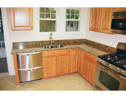71-73 Athelstane Road, Unit 1 Newton, MA 02459 - Photo 4 of 16 a kitchen with stainless steel appliances granite countertop a stove a sink and a microwave