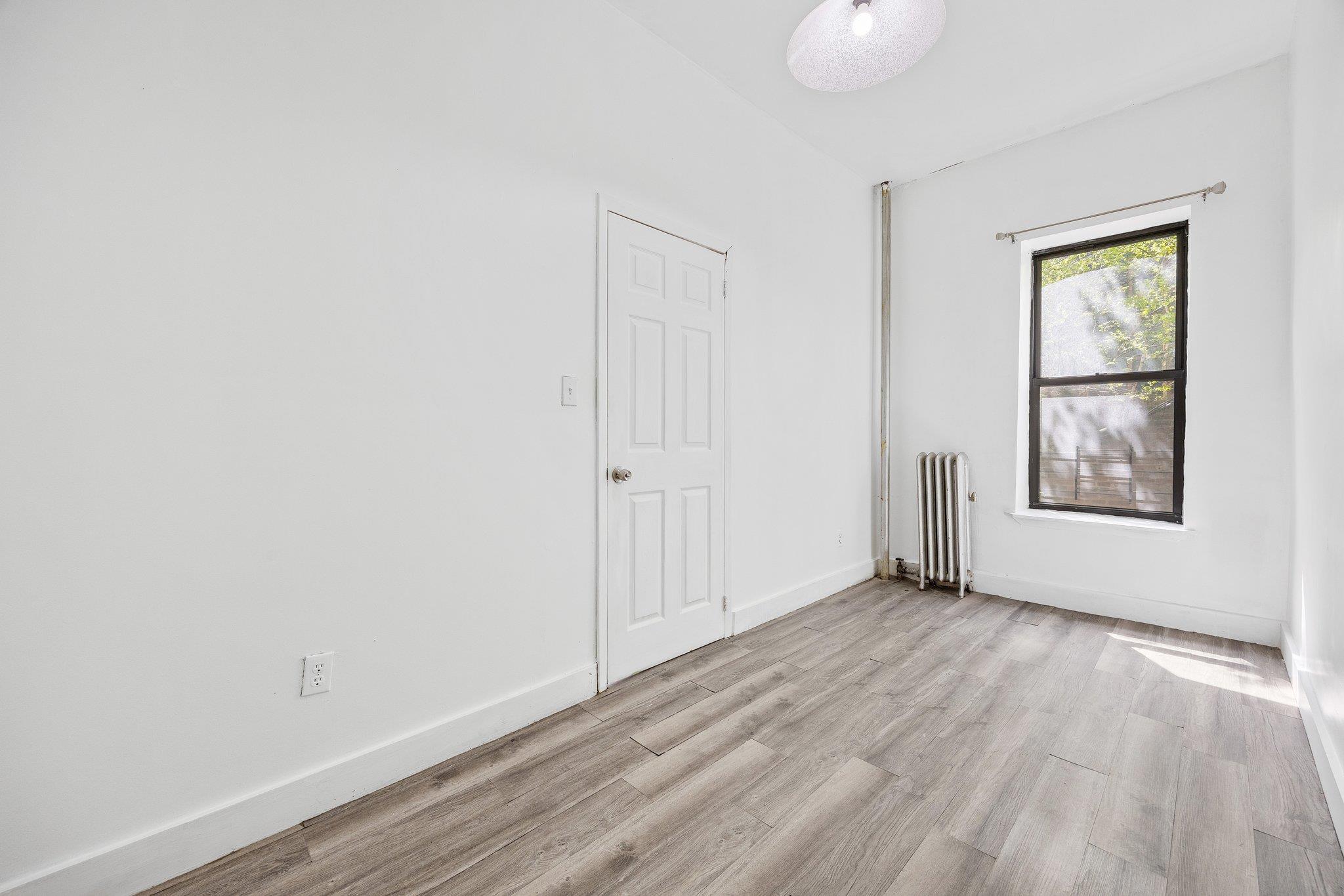 72 Richardson Street, Unit 4 Brooklyn, NY 11211 - Photo 4 of 17 Empty room featuring radiator, light wood finished floors, and baseboards