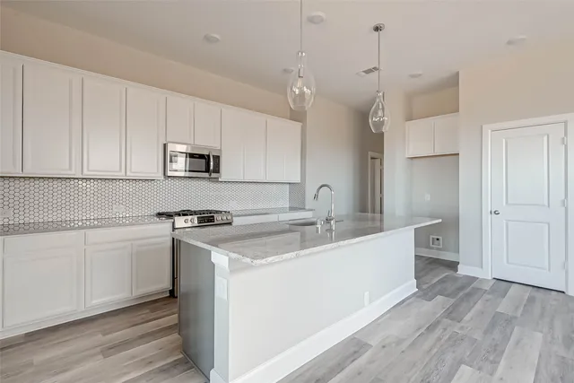 a kitchen with a sink stove and white cabinets