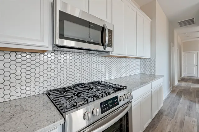 a stove top oven sitting inside of a kitchen