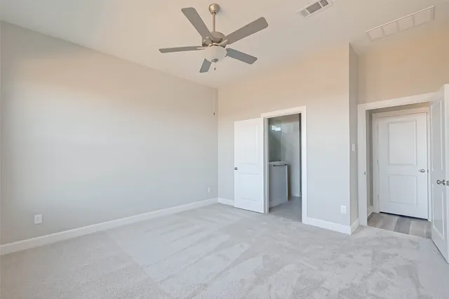 an empty room with closet and windows