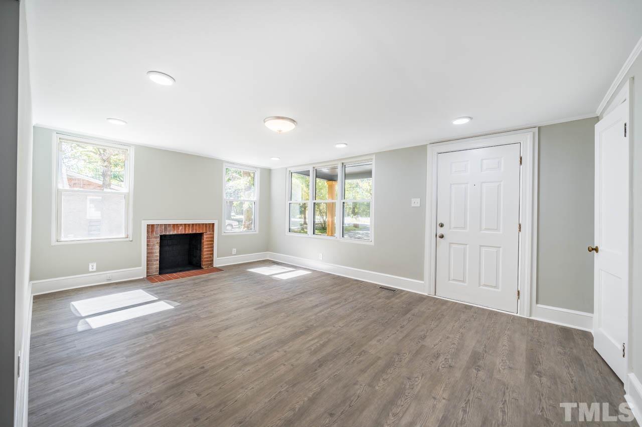 305 School House Road Efland, NC 27243 - Photo 15 of 35 an empty room with wooden floor fireplace and windows