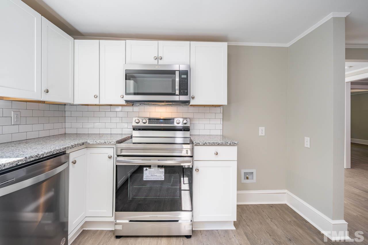 305 School House Road Efland, NC 27243 - Photo 28 of 35 a kitchen with cabinets stainless steel appliances and wooden floor
