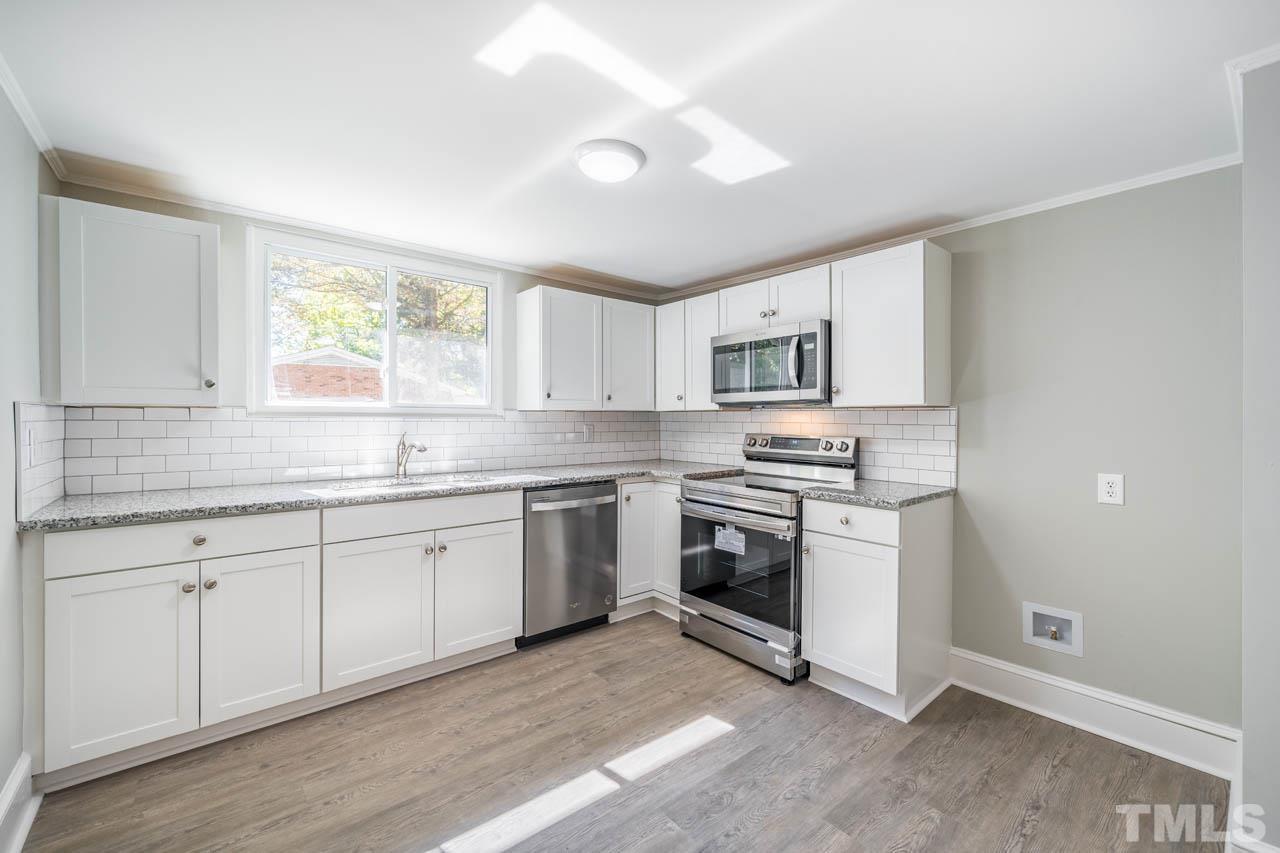 305 School House Road Efland, NC 27243 - Photo 34 of 35 a kitchen with granite countertop white cabinets and appliances