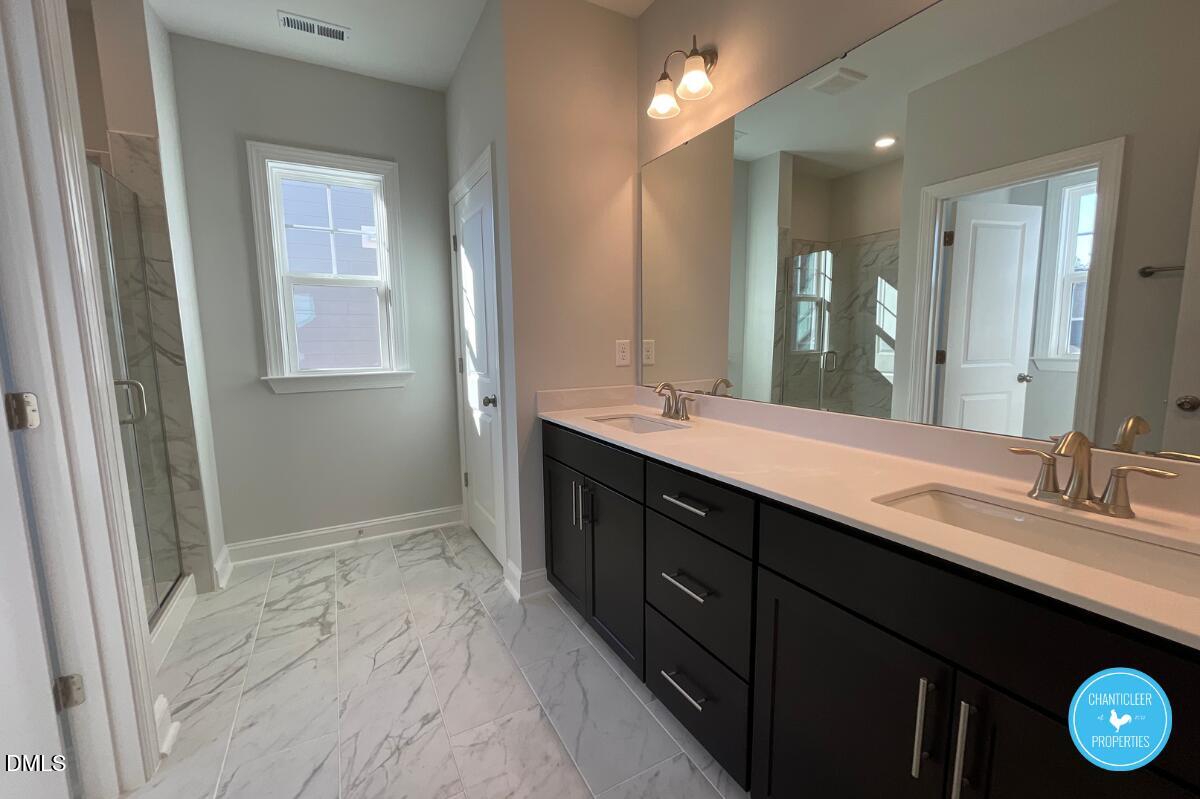 105 Chesapeake Way Chapel Hill, NC 27516 - Photo 21 of 26 a bathroom with a double vanity sink and a mirror