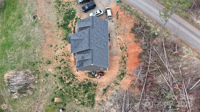 an aerial view of house with yard and mountain view in back