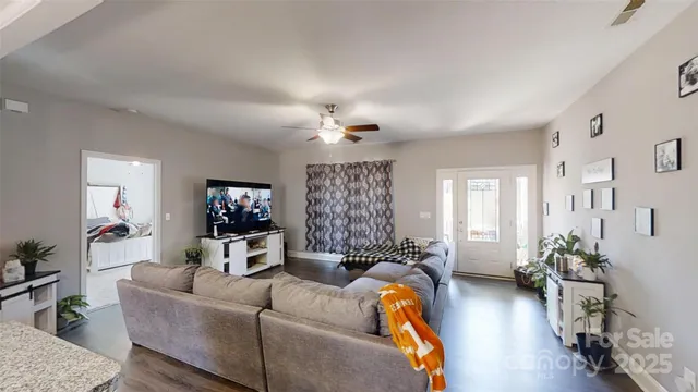 a large living room with stainless steel appliances kitchen island granite countertop furniture and a large window