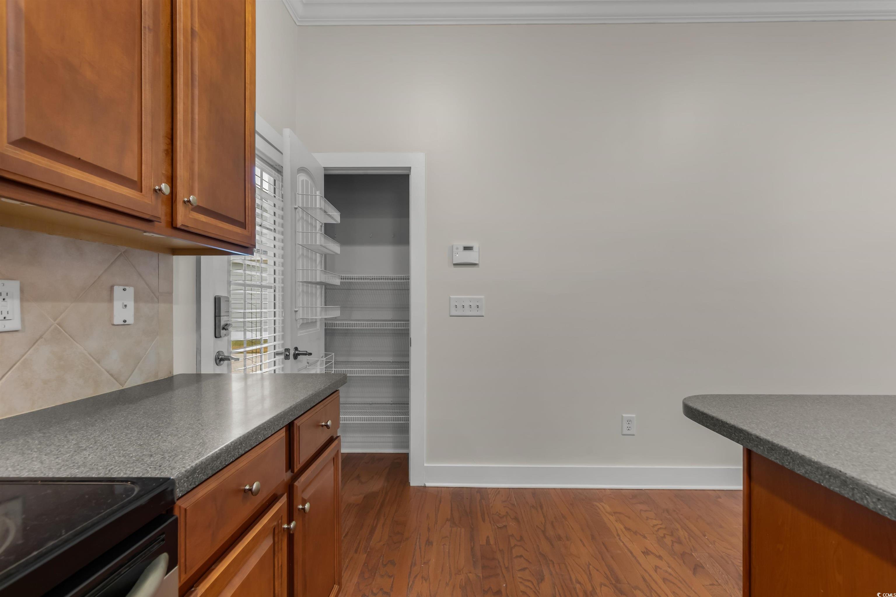 2006 Heritage Loop Myrtle Beach, SC 29577 - Photo 11 of 33 Kitchen featuring dark countertops, dark wood finished floors, brown cabinetry, electric range oven, and decorative backsplash