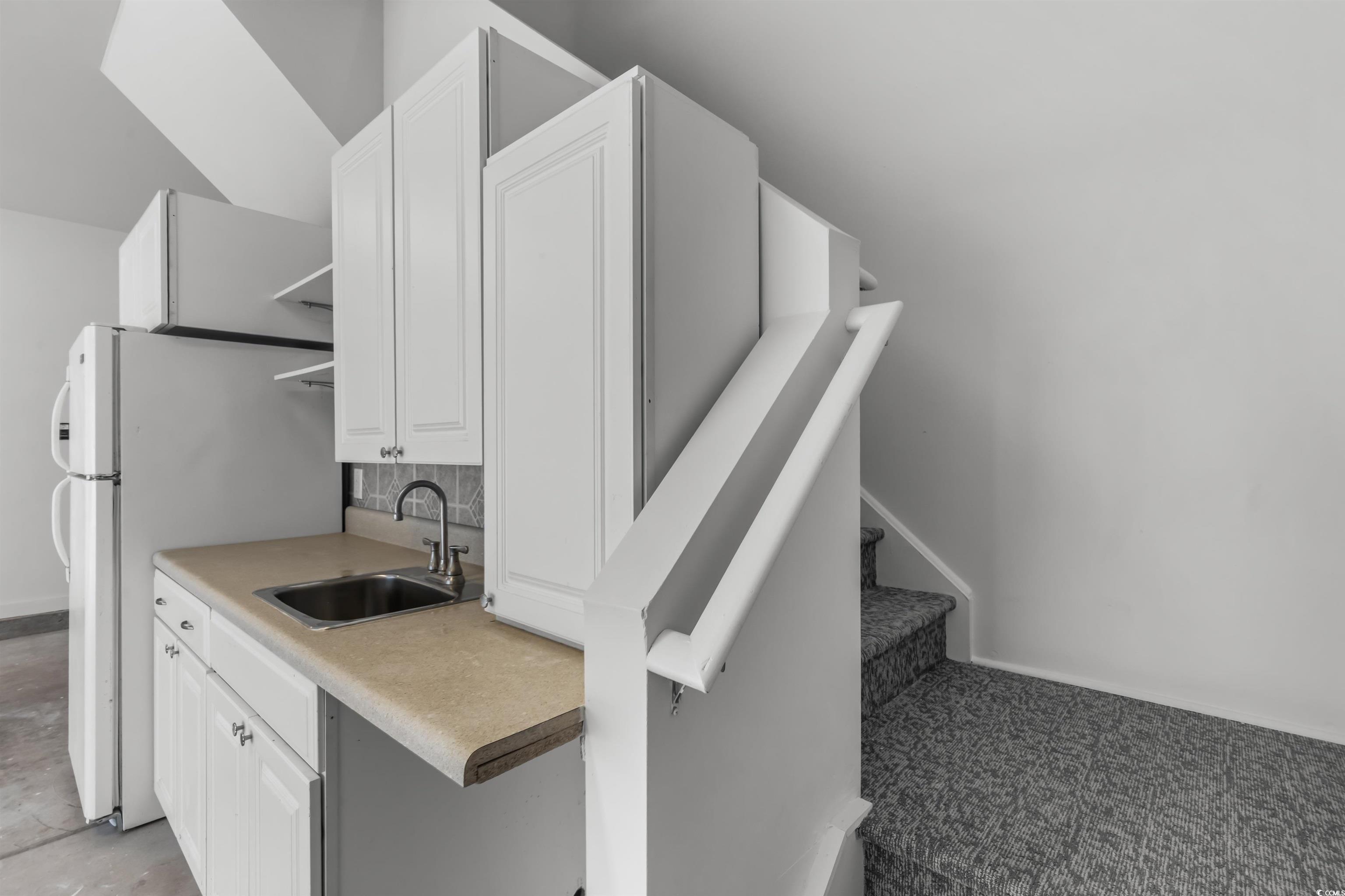 2006 Heritage Loop Myrtle Beach, SC 29577 - Photo 23 of 33 Kitchen featuring white cabinetry, light countertops, freestanding refrigerator, and open shelves