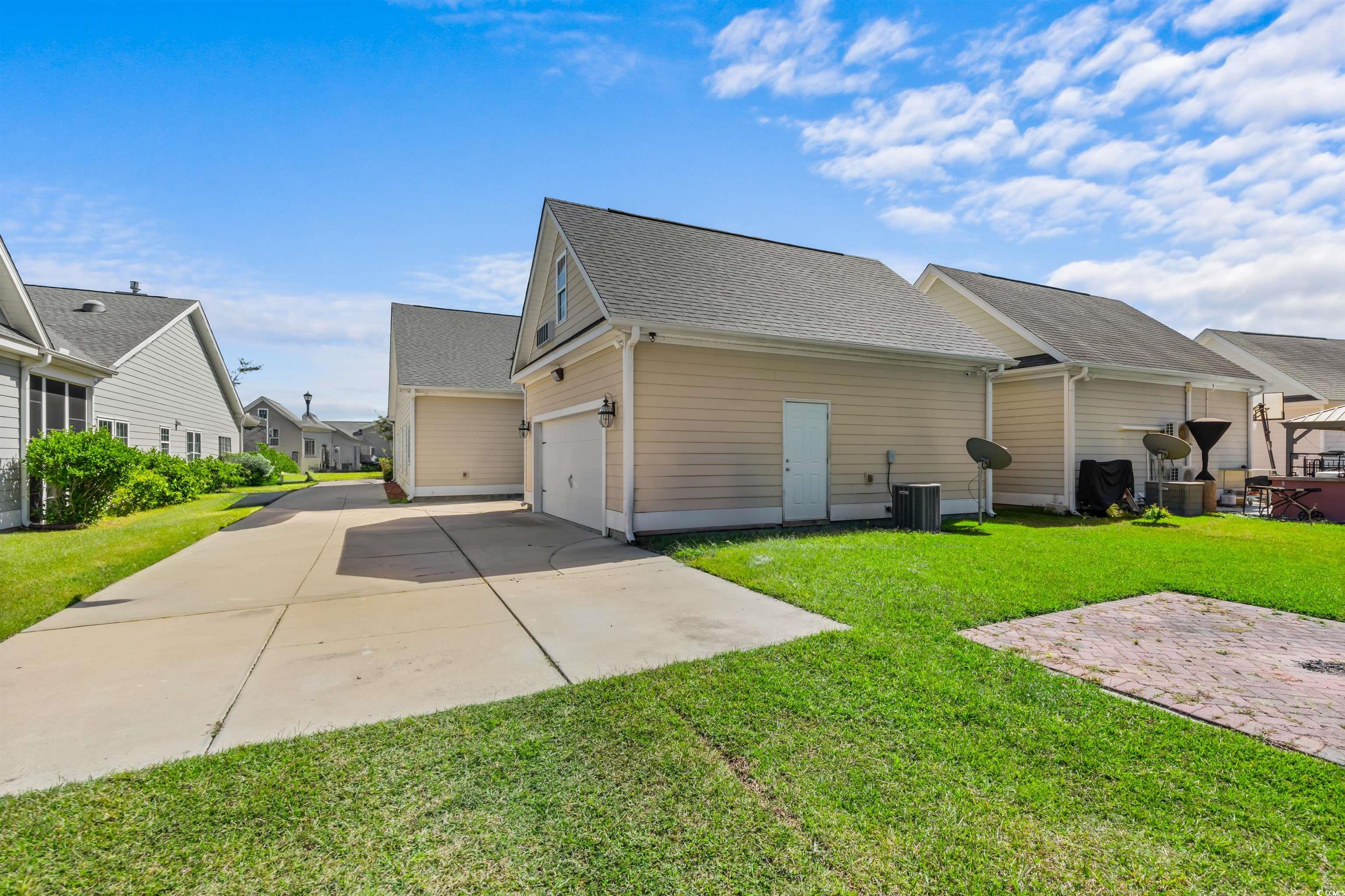 2006 Heritage Loop Myrtle Beach, SC 29577 - Photo 29 of 33 View of property exterior featuring a shingled roof, driveway, a residential view, a lawn, and an attached garage